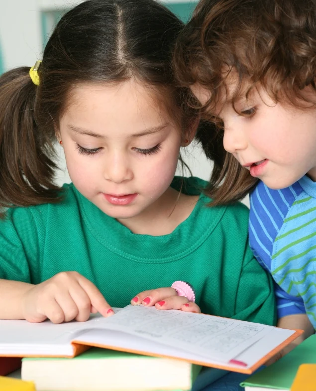 Crianças explorando um livro juntas